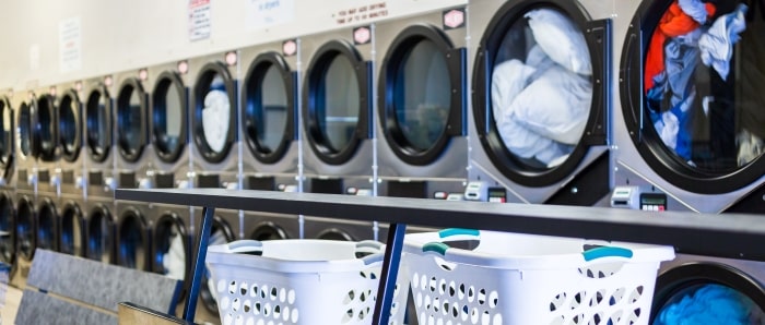 Row Of Washing Machines With Laundry Baskets Min 5